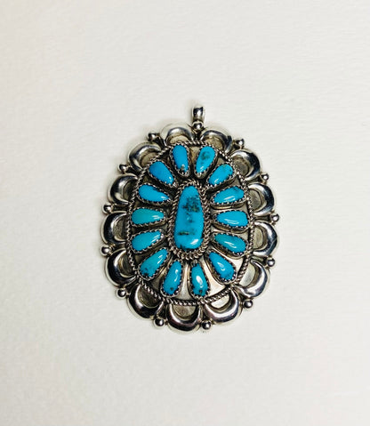 Southwest turquoise and sterling silver pendant signed by Native American artist.