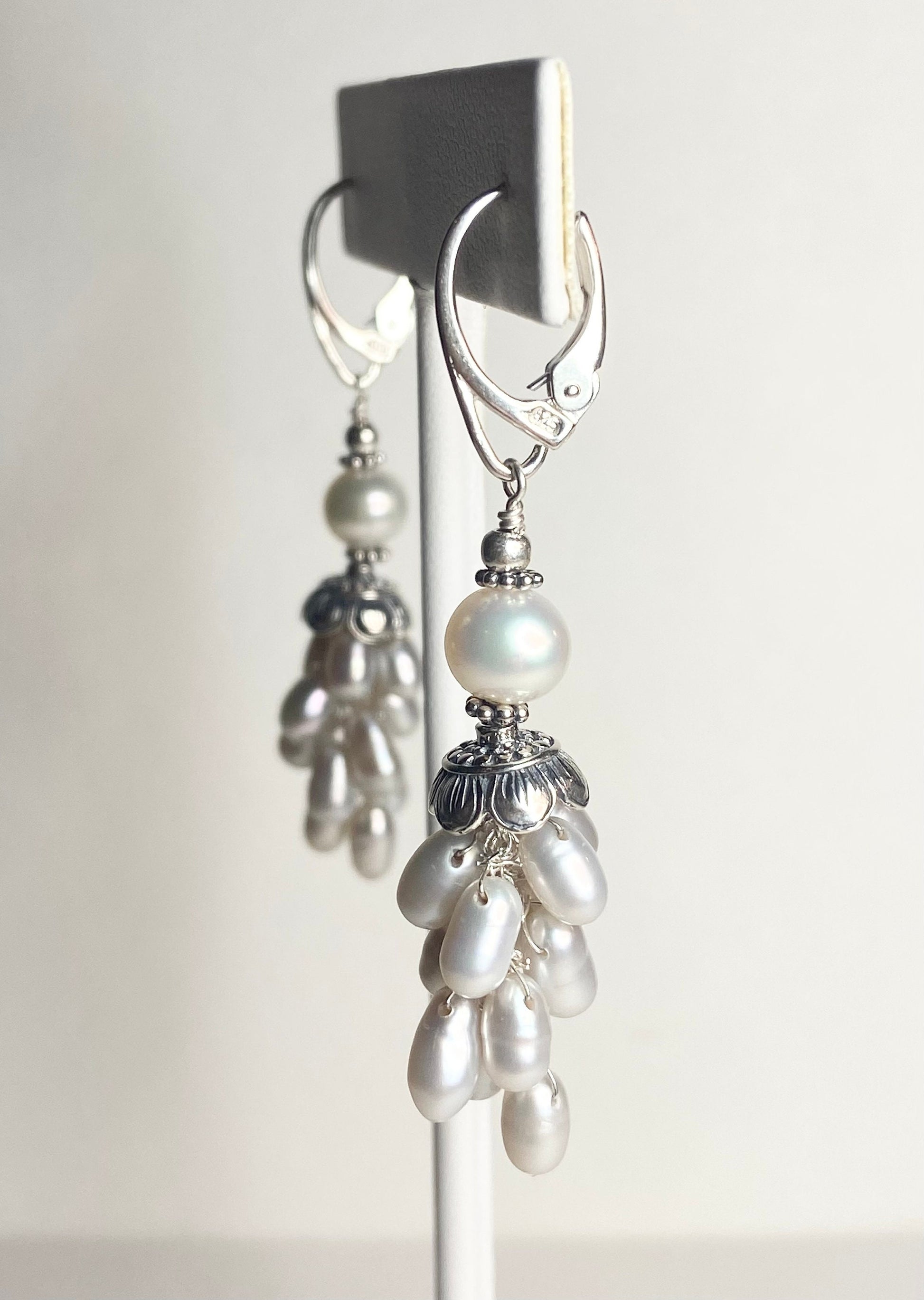 Silver dangle earrings with white freshwater pearls and lever backs.