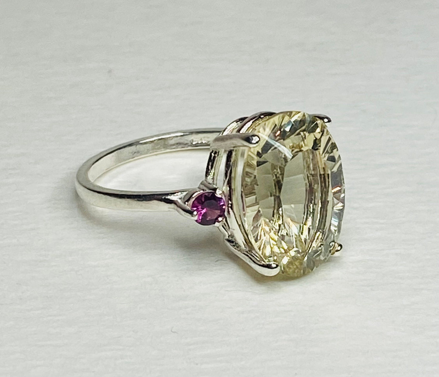 Sterling silver ring with a large oval Oregon sunstone and two small rhodolite garnets.