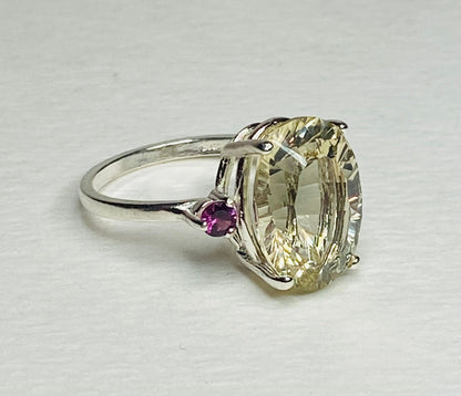 Sterling silver ring with a large oval Oregon sunstone and two small rhodolite garnets.