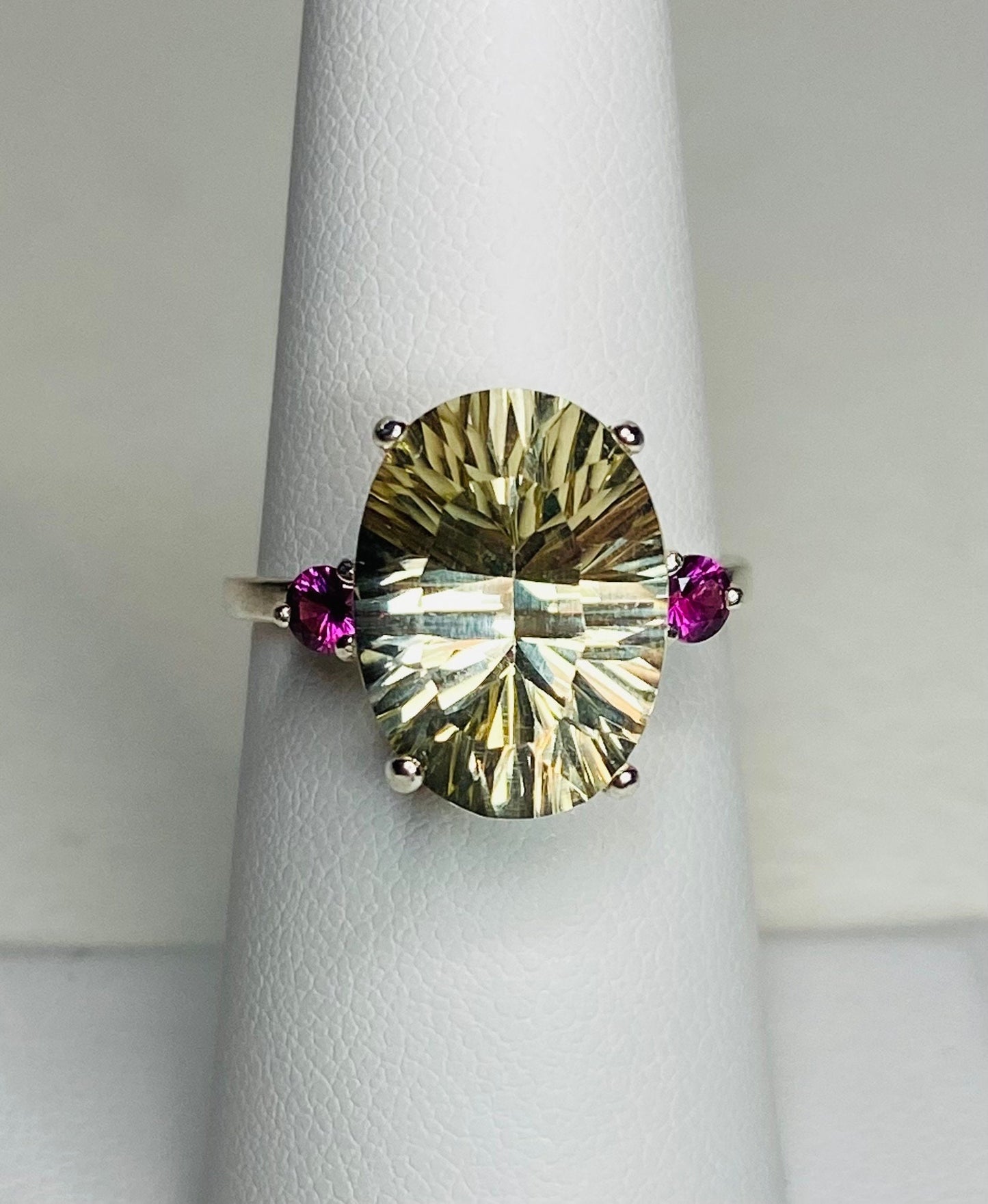 Sterling silver ring with oval faceted sunstone and two round rhodolite garnets.