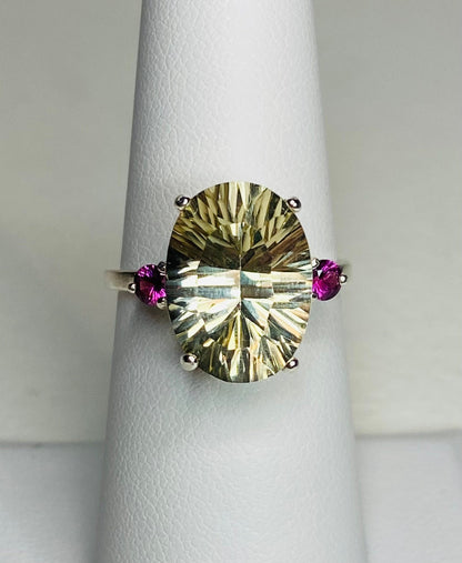 Sterling silver ring with oval faceted sunstone and two round rhodolite garnets.