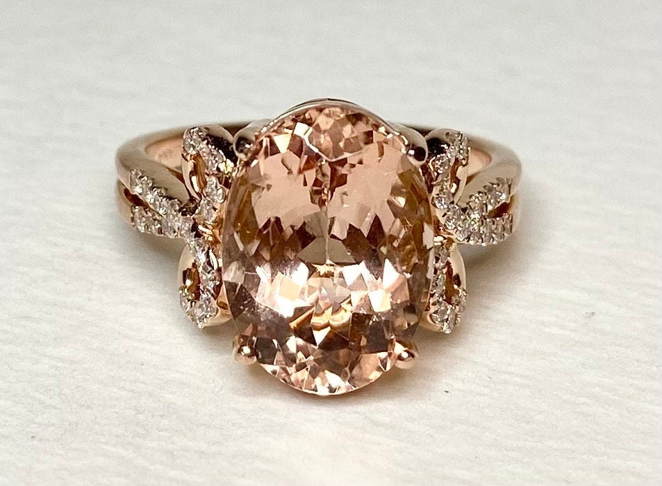 18k rose gold ring with oval morganite and diamond accents.