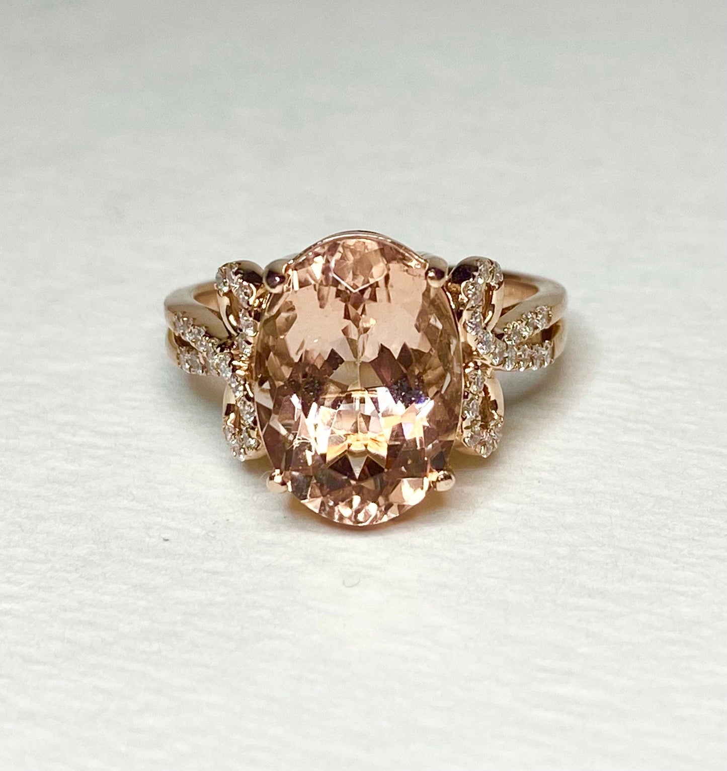 18k rose gold ring with oval morganite and diamond accents.