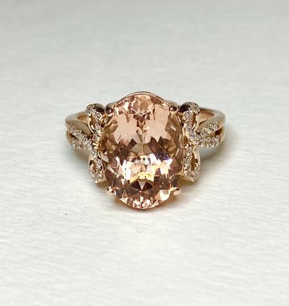 18k rose gold ring with oval morganite and diamond accents.