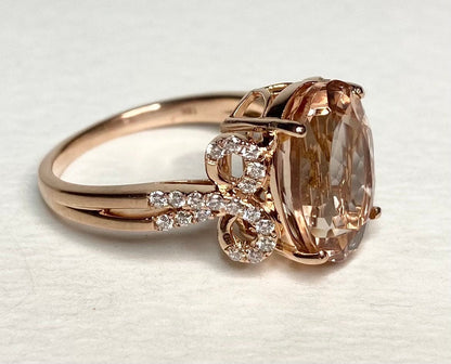 18k rose gold ring with oval morganite and diamond bow detail.