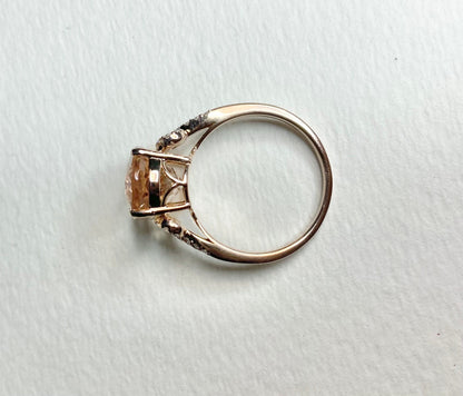 18k rose gold ring with oval morganite and diamond accents.