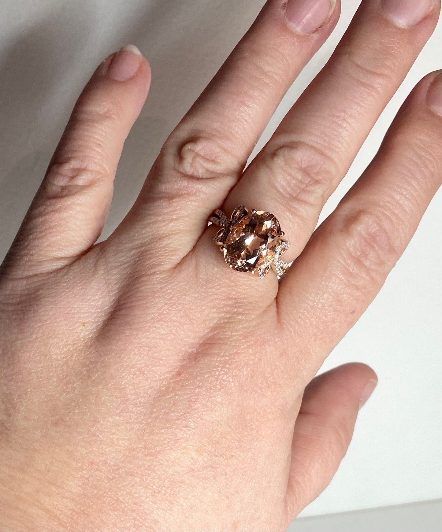 Oval morganite and diamond bow ring in rose gold.