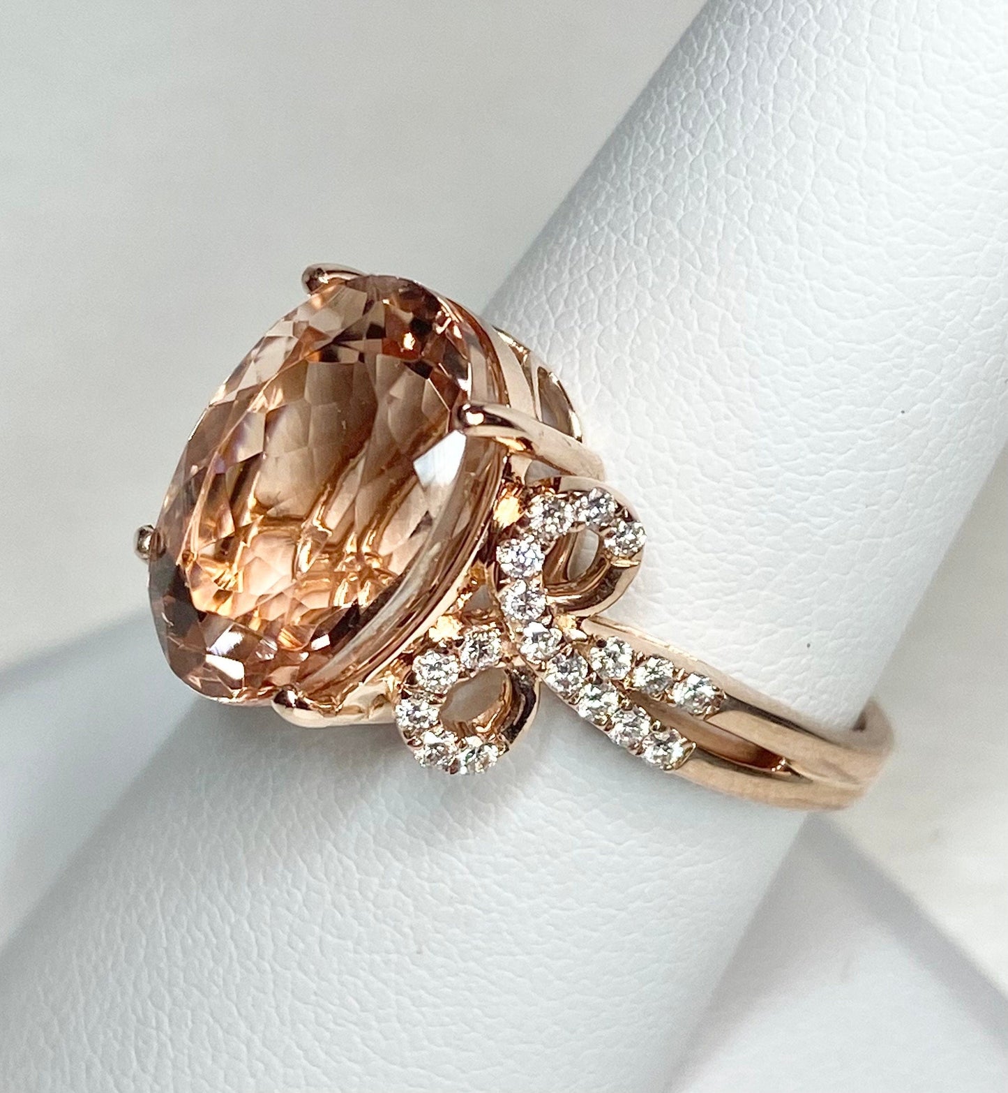 18k rose gold ring with oval morganite and diamond bow detail.