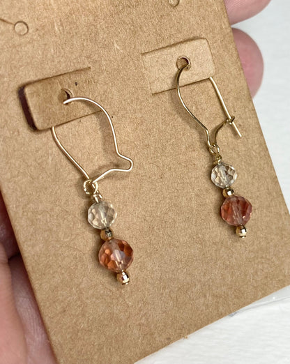 Solid 14k gold dangle earrings with faceted Oregon Sunstone beads in light yellow and red.