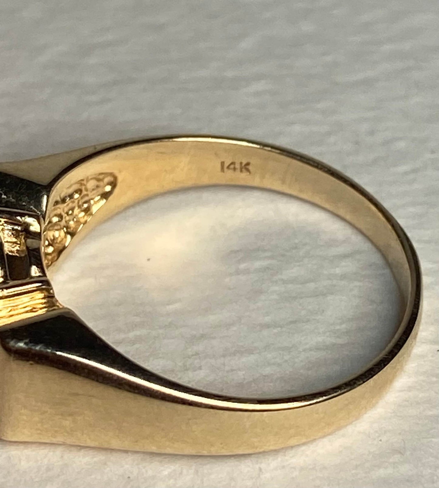 A solid 14k yellow gold ring with a bow design, marked 14K.