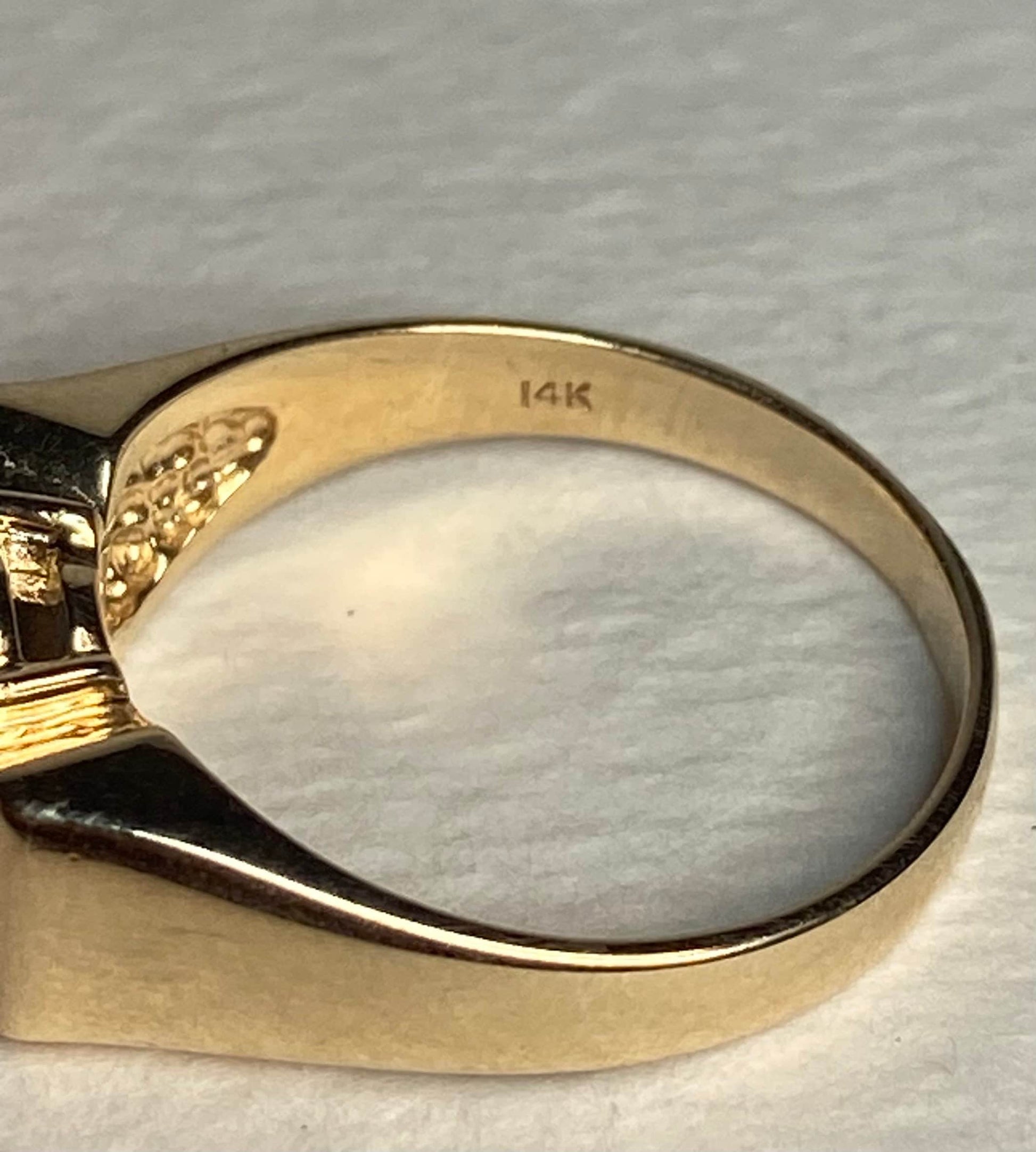 A solid 14k yellow gold ring with a bow design, marked 14K.