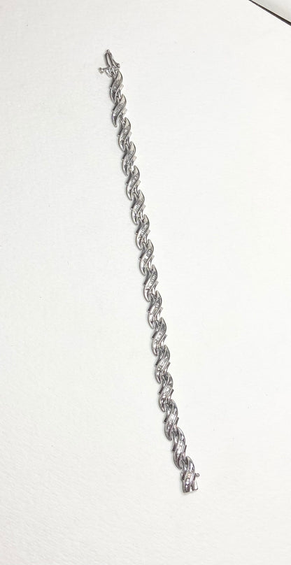Sterling silver tennis bracelet with baguette diamonds and rhodium plating.