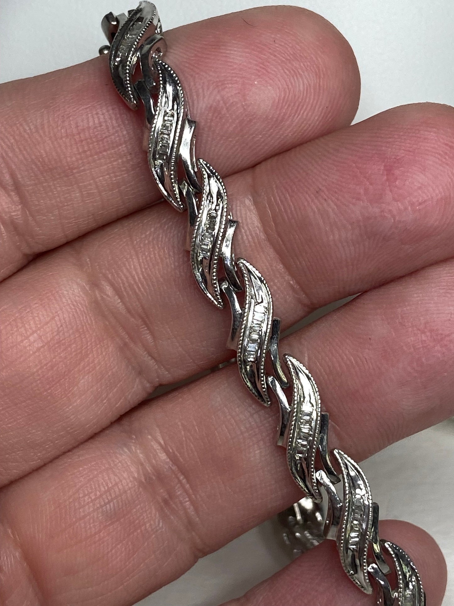 Rhodium plated sterling silver tennis bracelet with baguette diamonds.