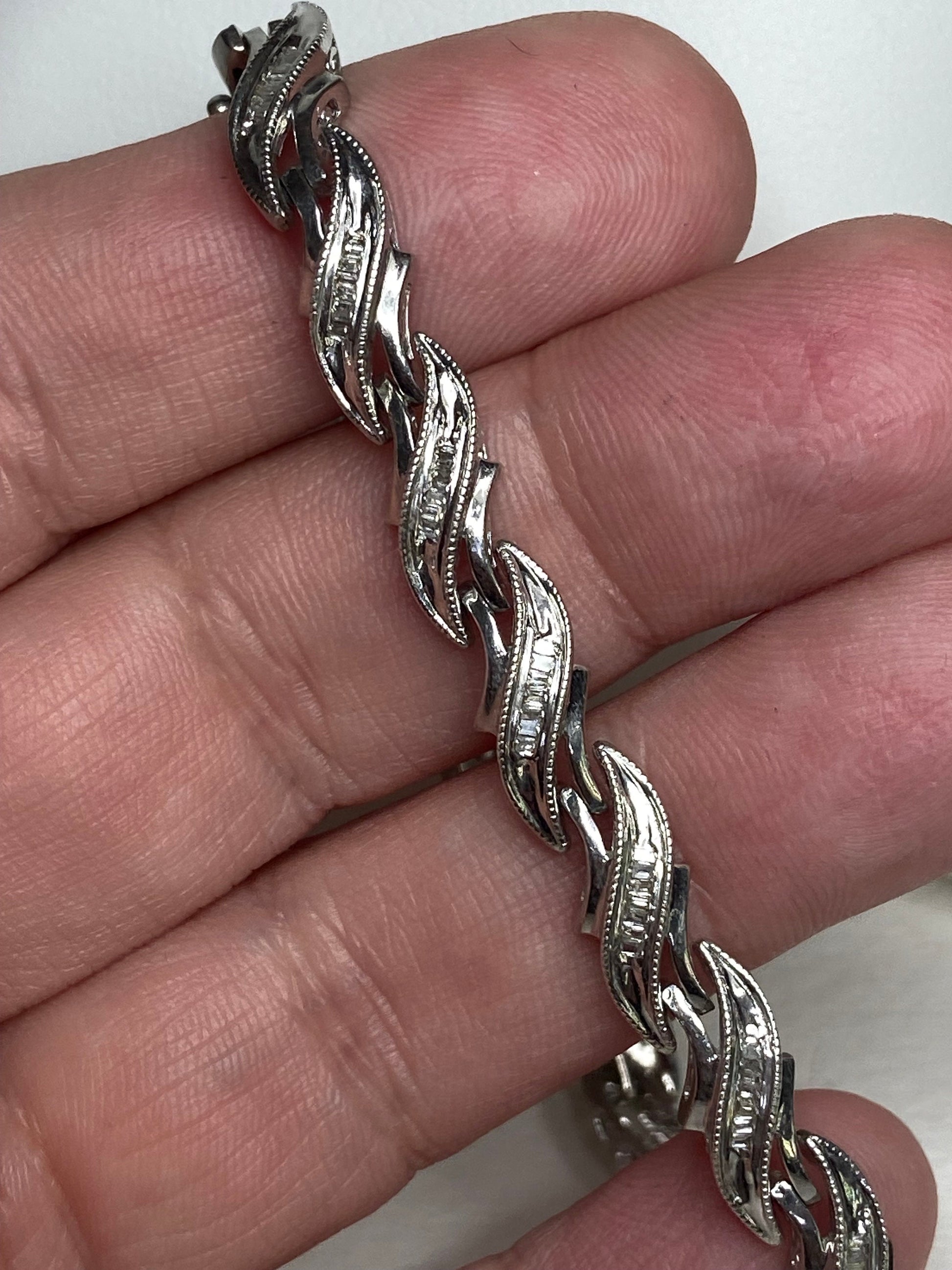Rhodium plated sterling silver tennis bracelet with baguette diamonds.