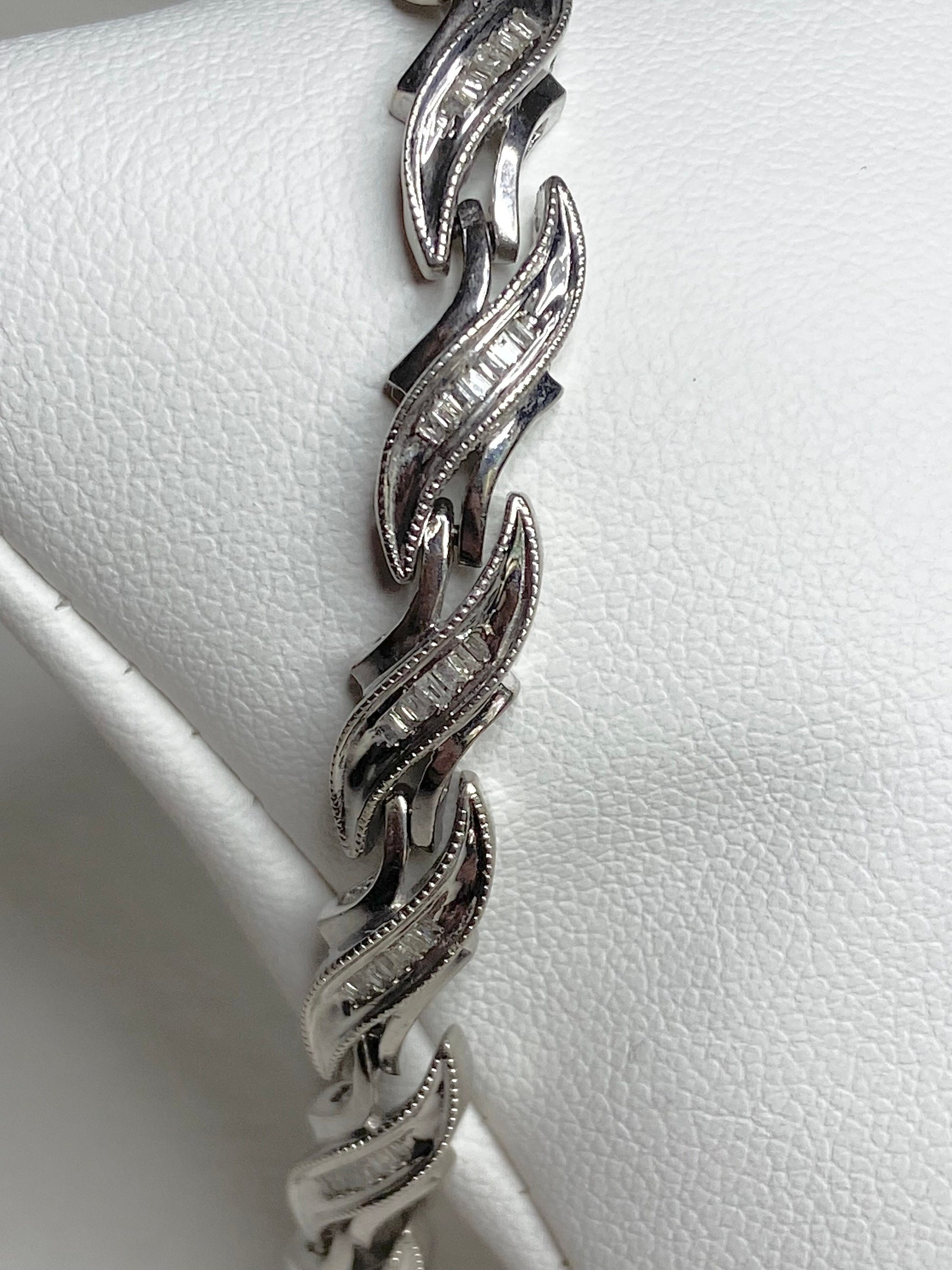 Rhodium plated sterling silver tennis bracelet with baguette diamonds.