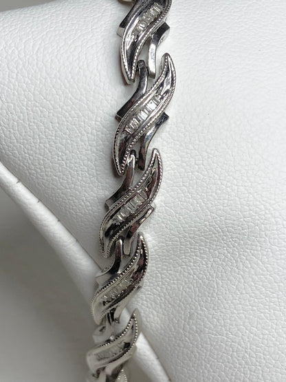 Rhodium plated sterling silver tennis bracelet with baguette diamonds.