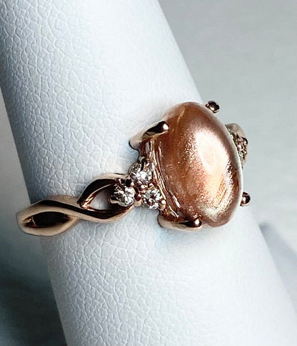 Oval Oregon sunstone and diamond ring in 10k rose gold.