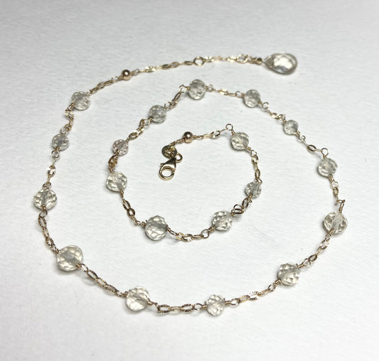 A 14k yellow gold choker necklace with light yellow faceted beads and a briolette charm.