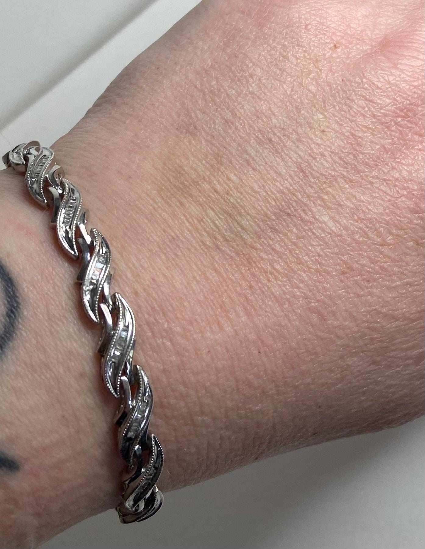 Rhodium plated sterling silver tennis bracelet with baguette diamonds.