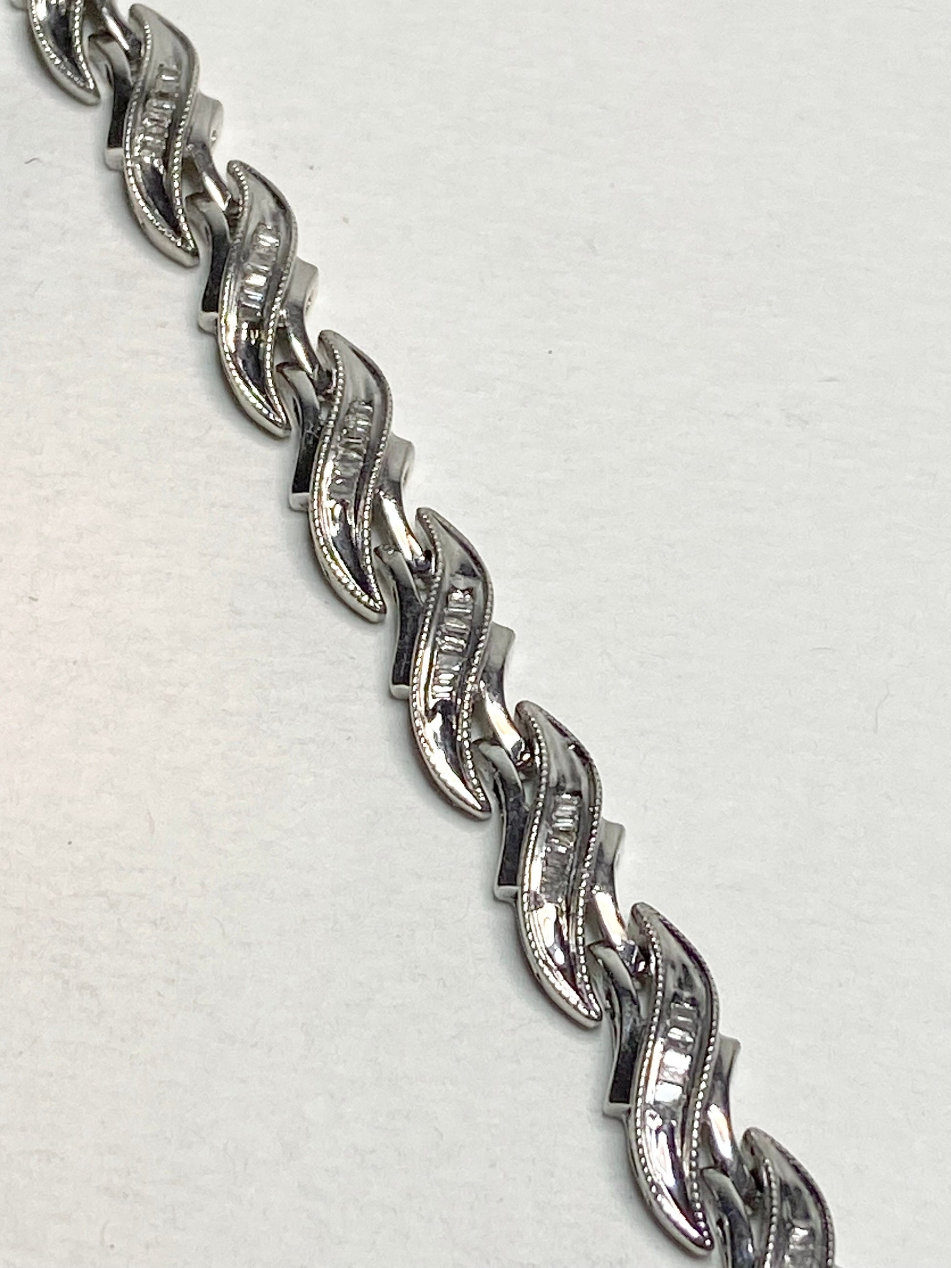 Rhodium plated sterling silver tennis bracelet with baguette diamonds.