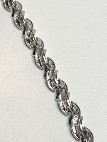 Rhodium plated sterling silver tennis bracelet with baguette diamonds.