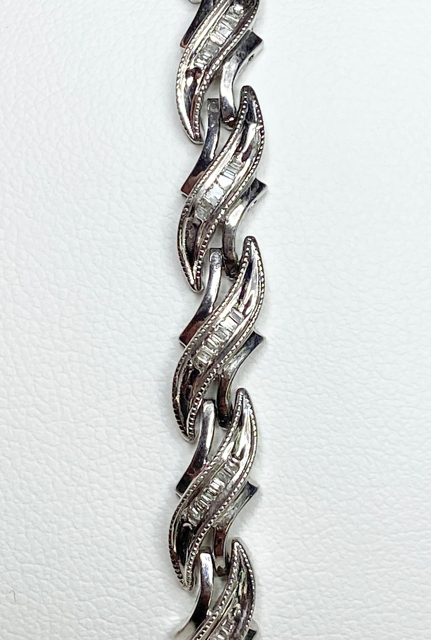 Rhodium plated sterling silver tennis bracelet with baguette diamonds.