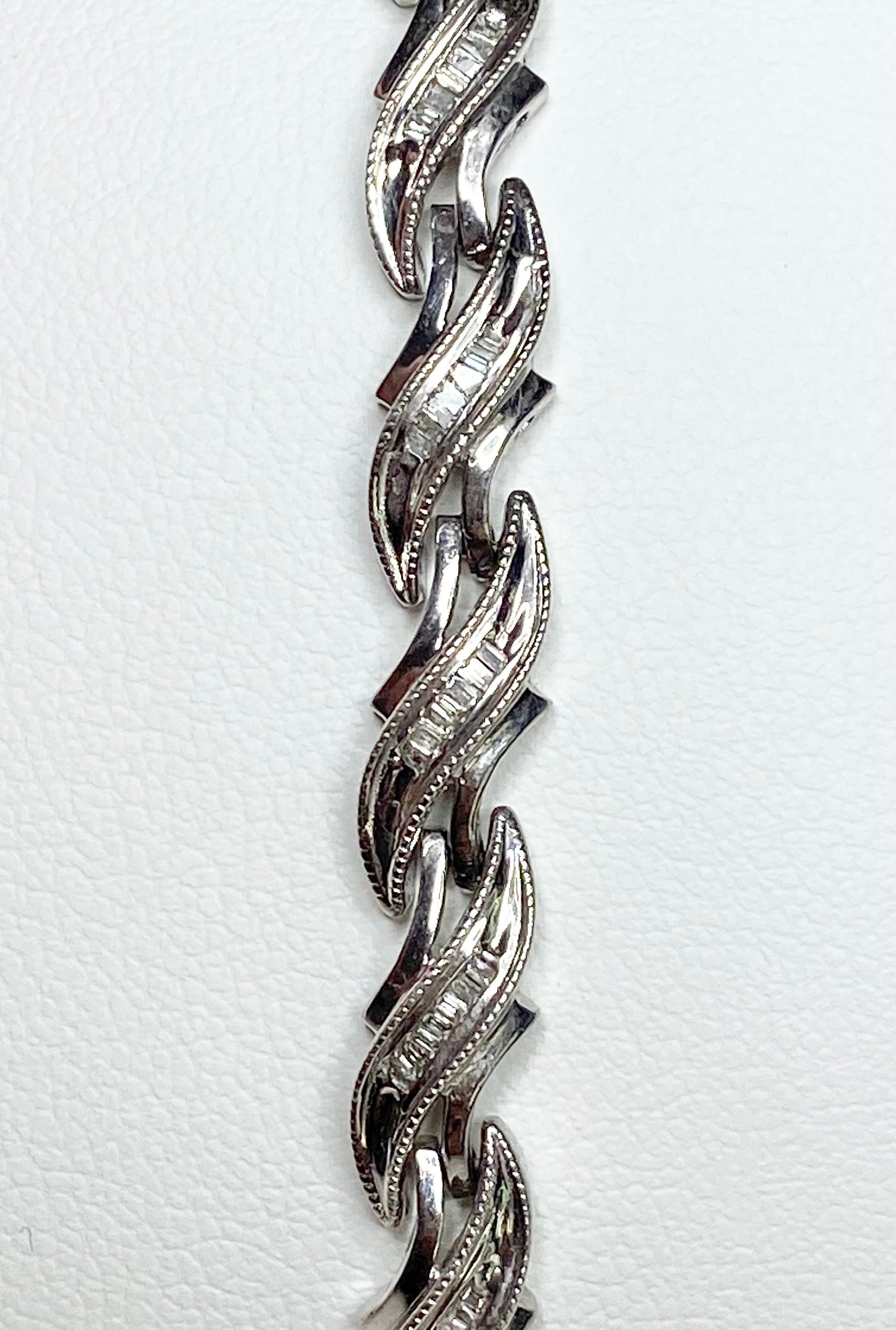 Rhodium plated sterling silver tennis bracelet with baguette diamonds.
