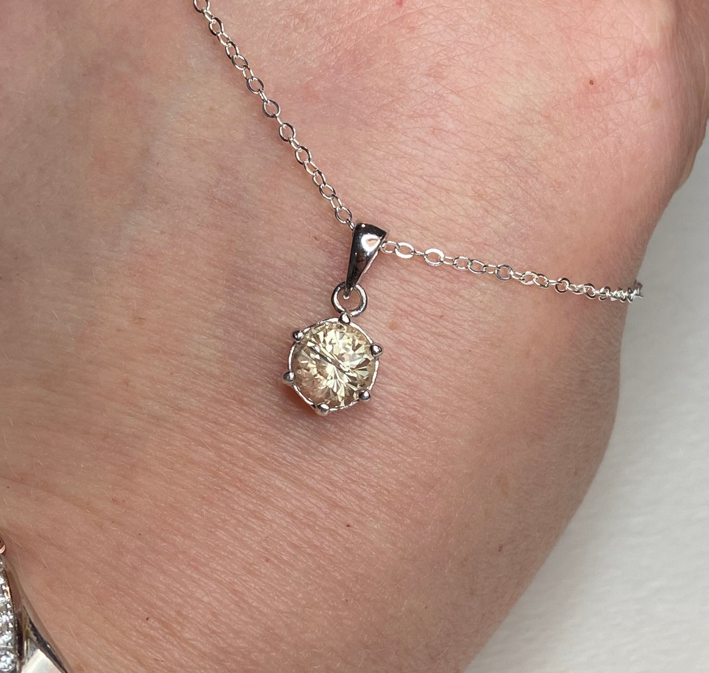 Oregon Sunstone pendant necklace with a round, 7mm, 1.51ct fancy precision cut sunstone in a sterling silver setting.