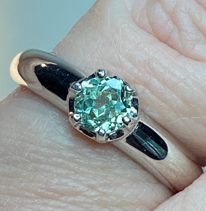 Sterling silver ring with a round, green chrysoberyl gemstone in a solitaire setting.