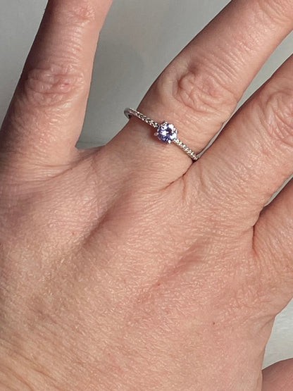 Sterling silver ring with a small round tanzanite stone.