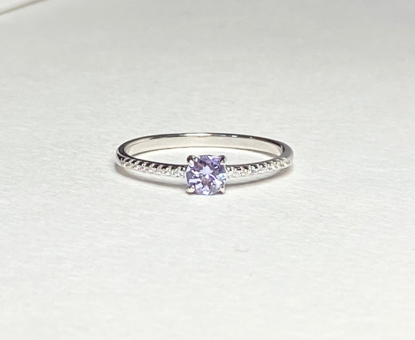 Sterling silver ring with a round tanzanite and small accent stones.