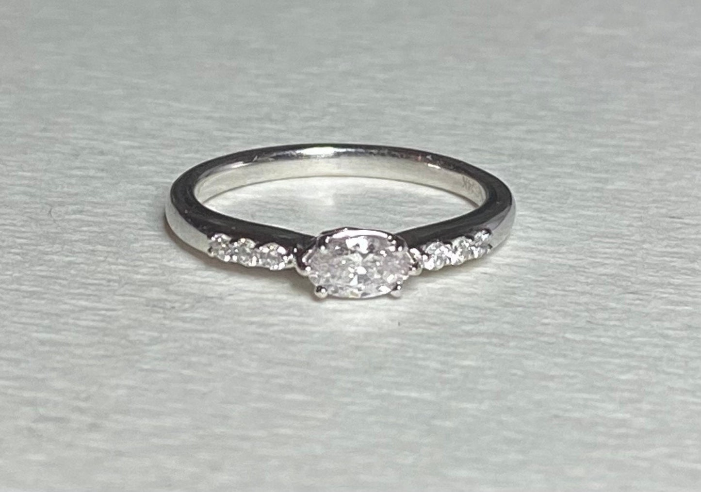 A 14k white gold ring with a marquise pink diamond and accent diamonds.