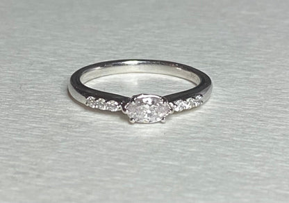 A 14k white gold ring with a marquise pink diamond and accent diamonds.