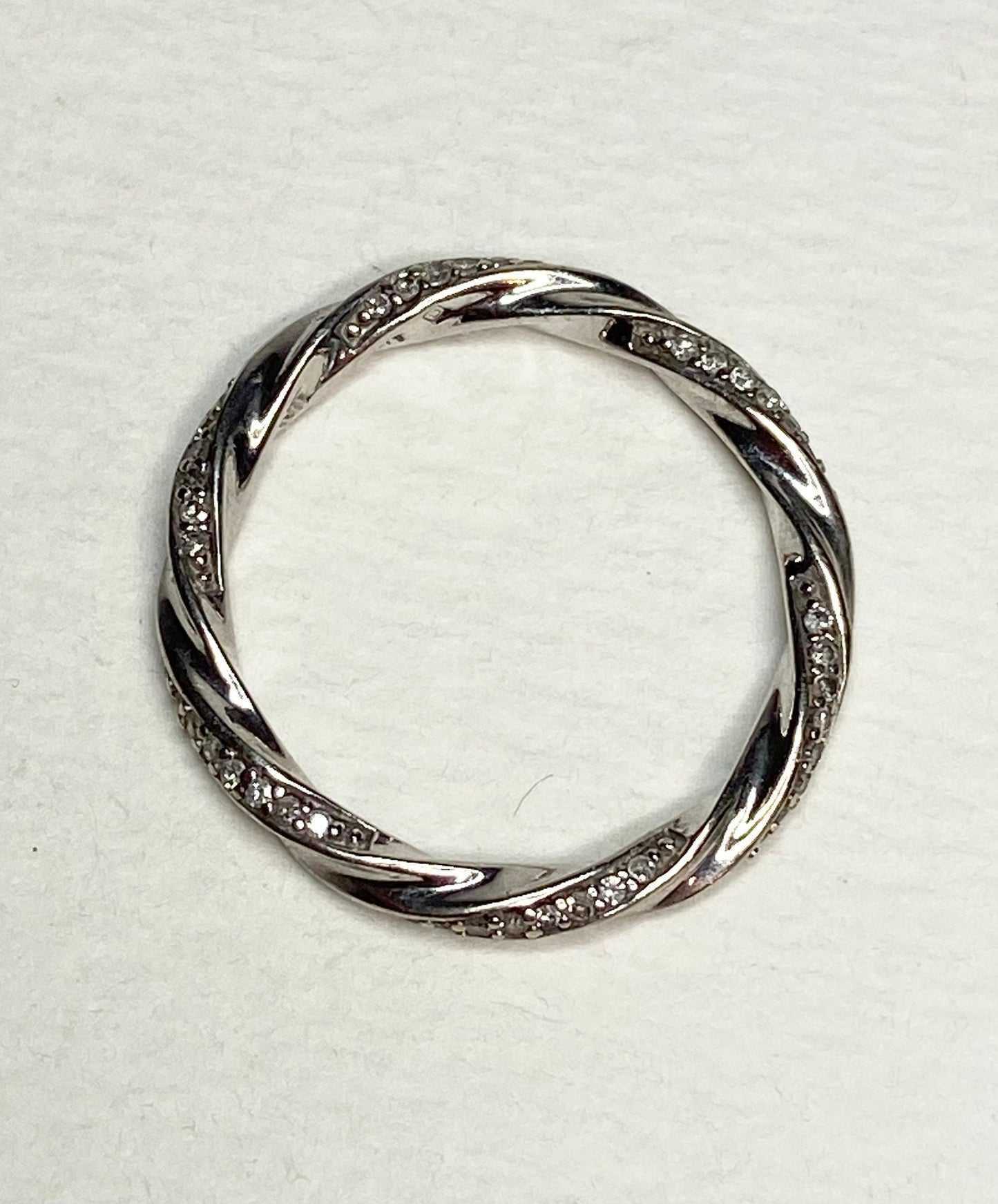 A twisted 10k white gold eternity band ring with 72 natural diamonds.