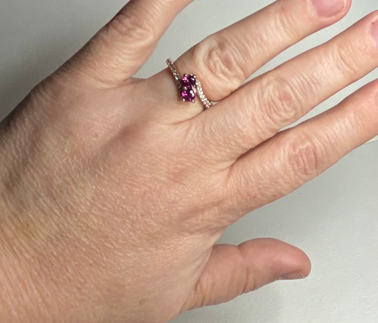 14k rose gold ring with two rhodolite garnets and diamonds.