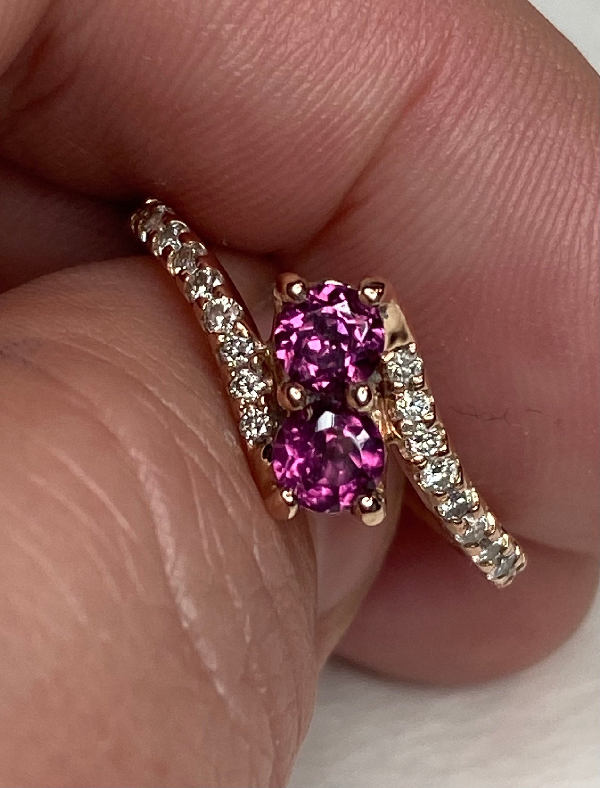 14k rose gold ring with two rhodolite garnets and diamonds.