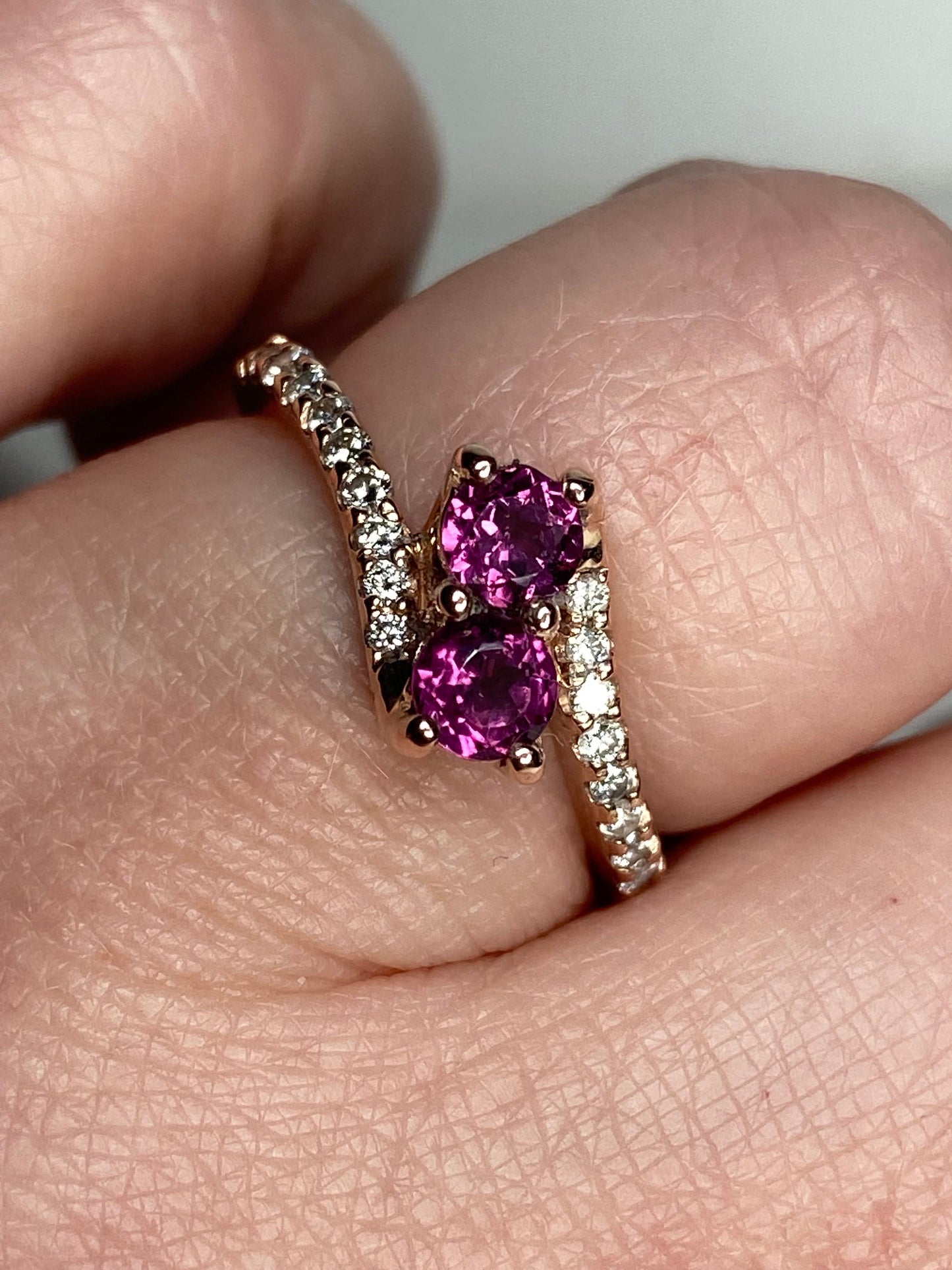 A 14k rose gold toi et moi ring with two rhodolite garnets and diamonds.
