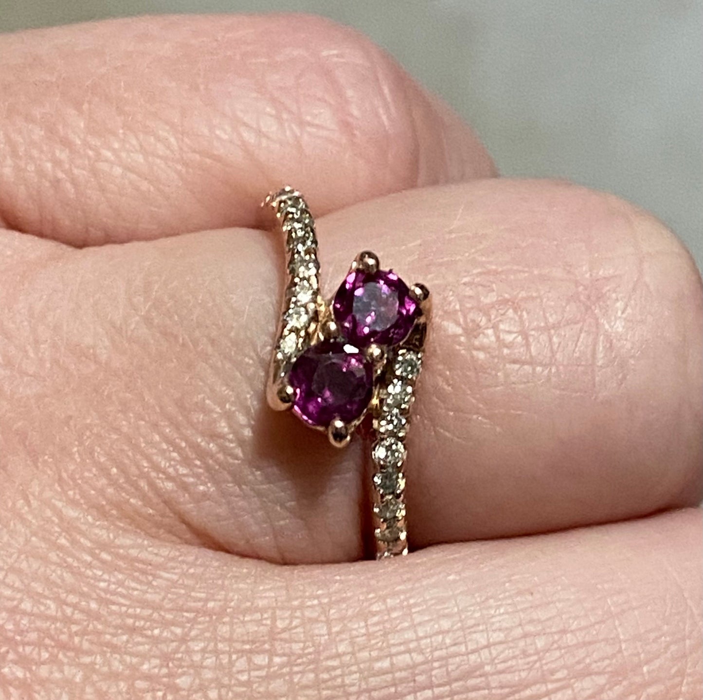 14k rose gold ring with two rhodolite garnets and diamonds.