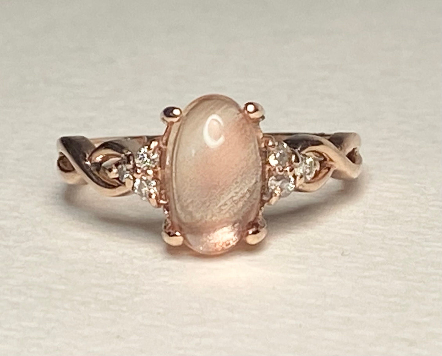 Oval Oregon sunstone and diamond ring in 10k rose gold.