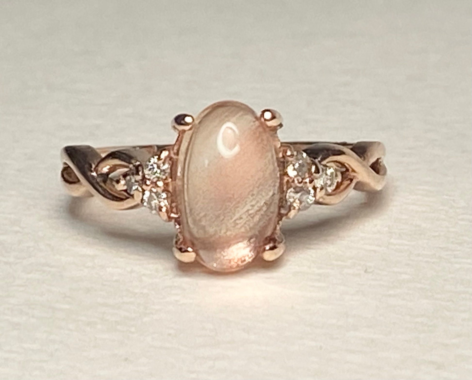 Oval Oregon sunstone and diamond ring in 10k rose gold.