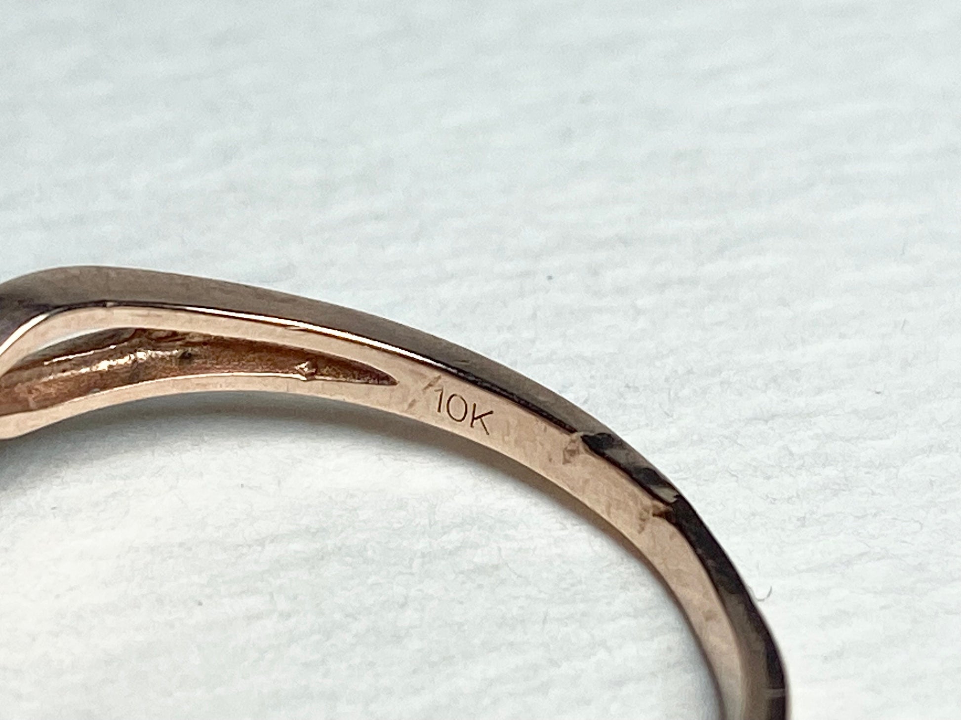 A 10k rose gold ring with a sunstone and diamonds.