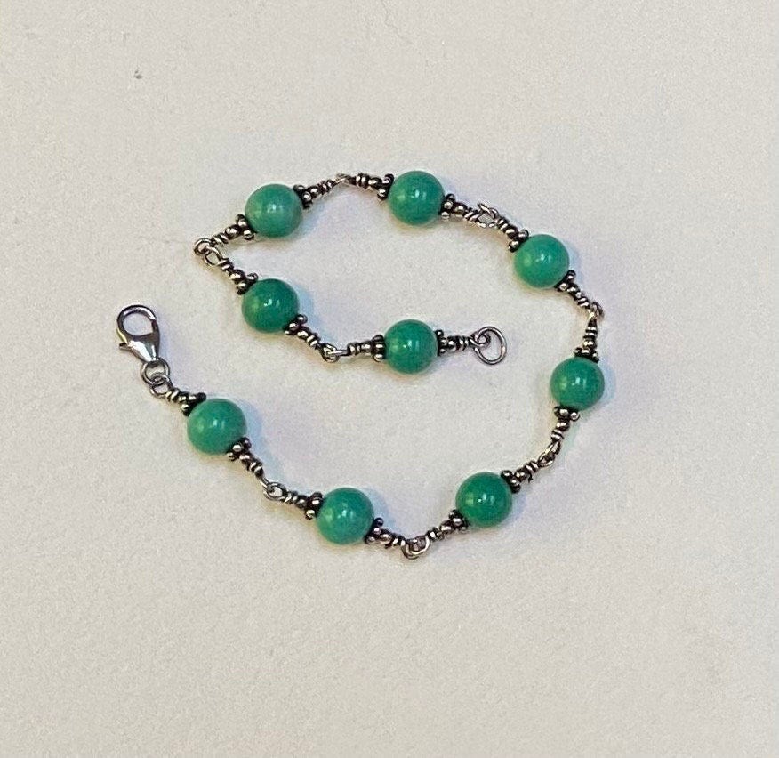 Sterling silver bracelet with round blue jasper beads and a lobster clasp.