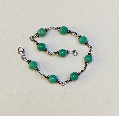 Sterling silver bracelet with round blue jasper beads and a lobster clasp.