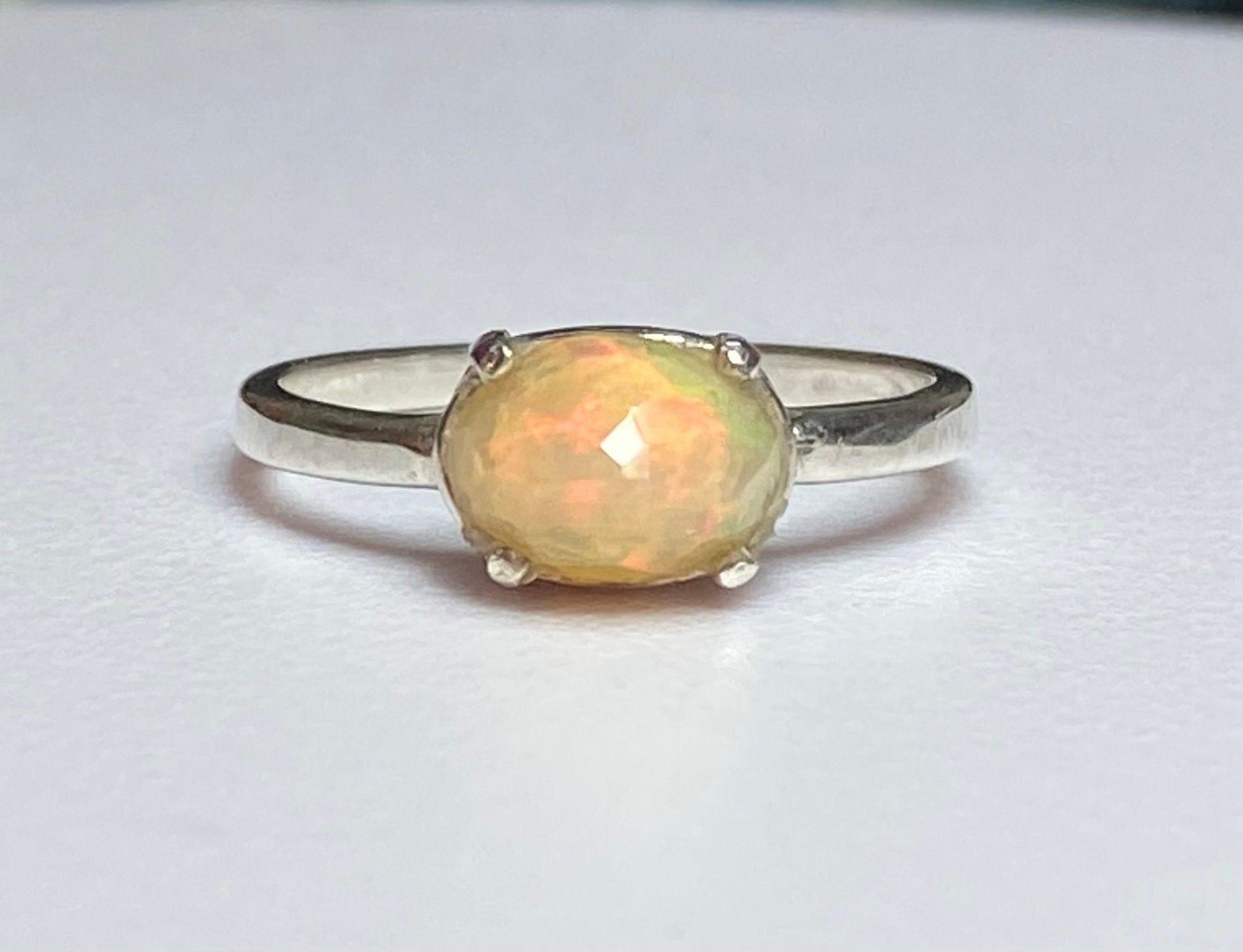 Sterling silver band ring with an oval faceted Ethiopian Wello opal.