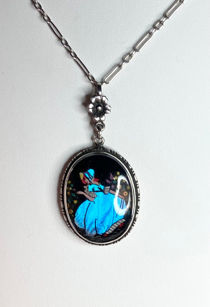 Sterling silver necklace with reverse painted morpho butterfly pendant featuring a lady in a garden.