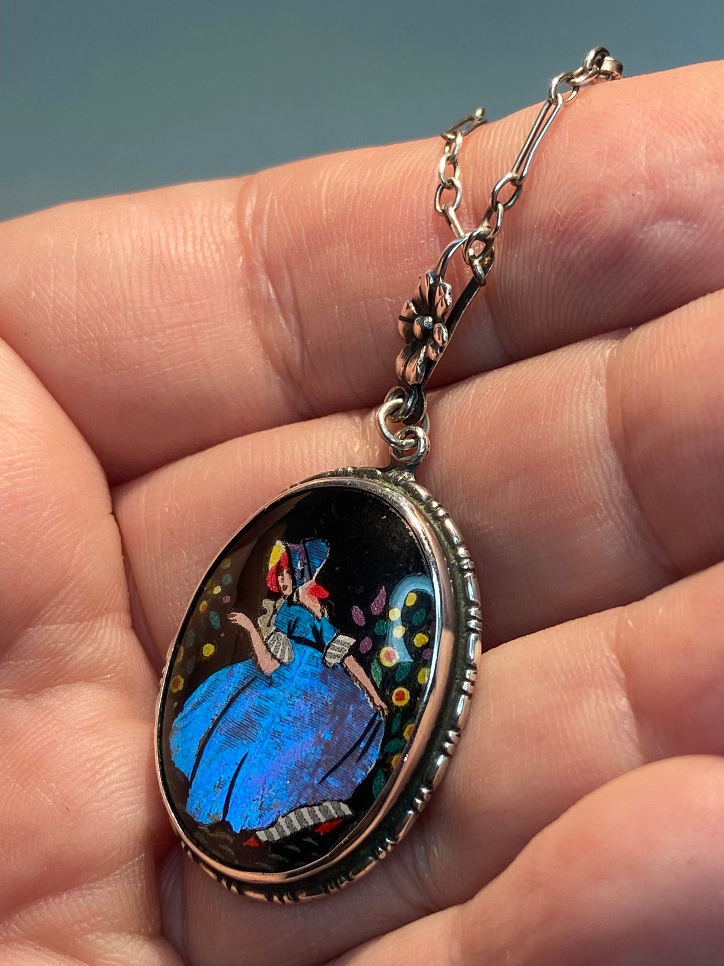 Sterling silver pendant necklace with reverse-painted morpho butterfly wing and a lady in a blue dress.