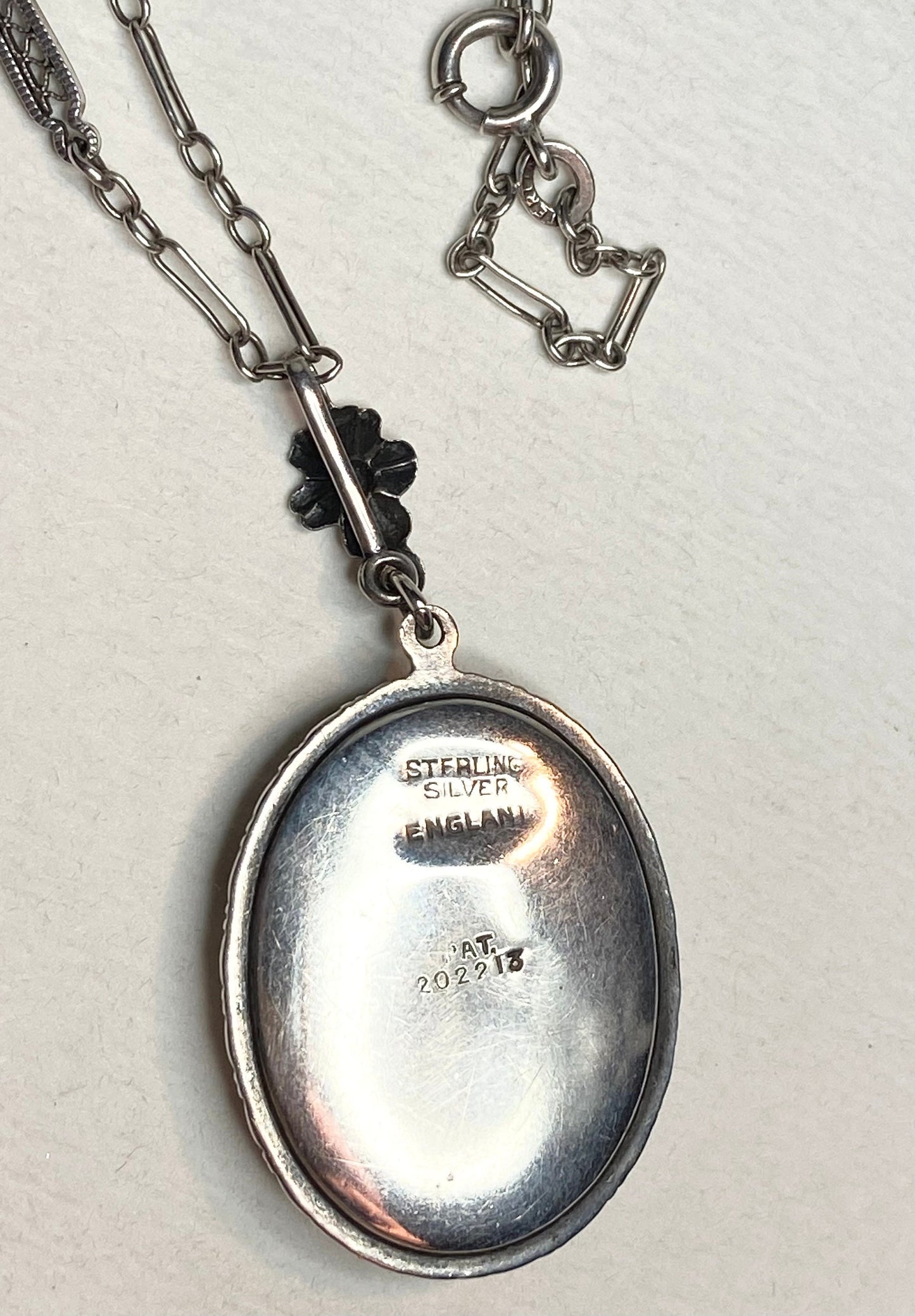 Sterling silver pendant necklace with a reverse-painted glass top featuring a lady in a garden.