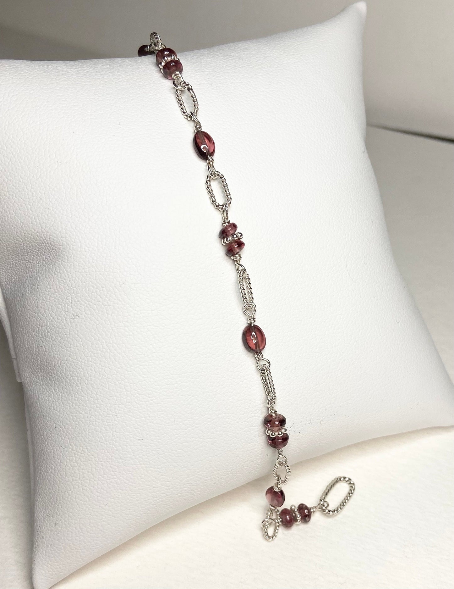 Sterling silver bracelet with oval and round rhodolite garnet beads.