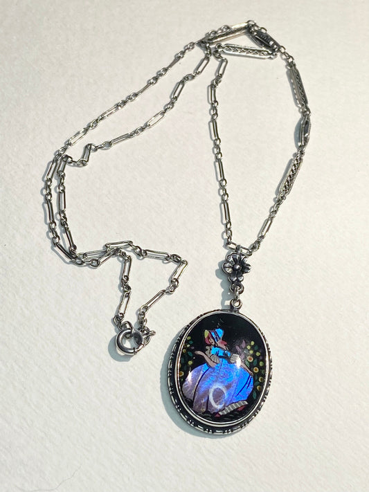 Sterling silver necklace with an oval pendant featuring a reverse-painted Morpho butterfly wing and a lady in a garden.